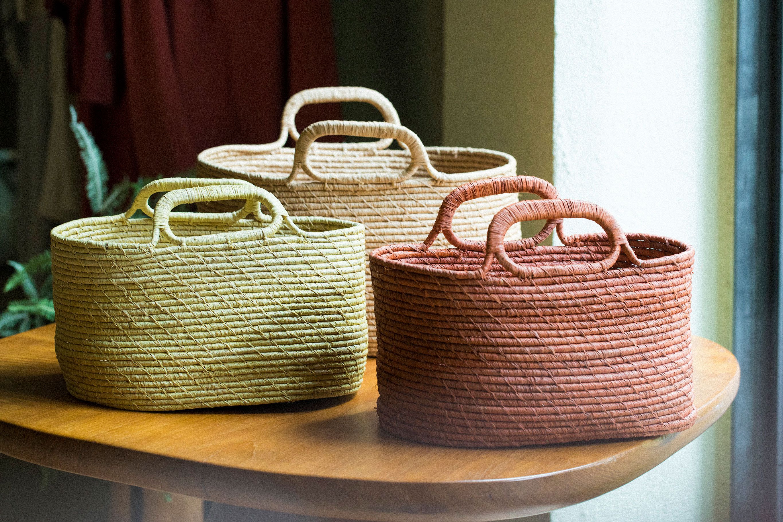 ラフィアのコイル編みのカゴはマダガスカル産。夏らしい色味のカゴで季節を楽しむ。小12,960円　大16,200円（どちらも税込）