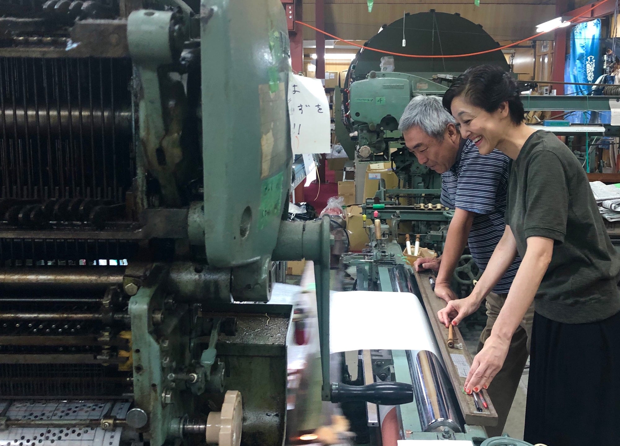 Seguchi is observing the warp thread made at the workshop in Yamanashi. “The origin of my motivation comes from the time interacting with the craftsmen”