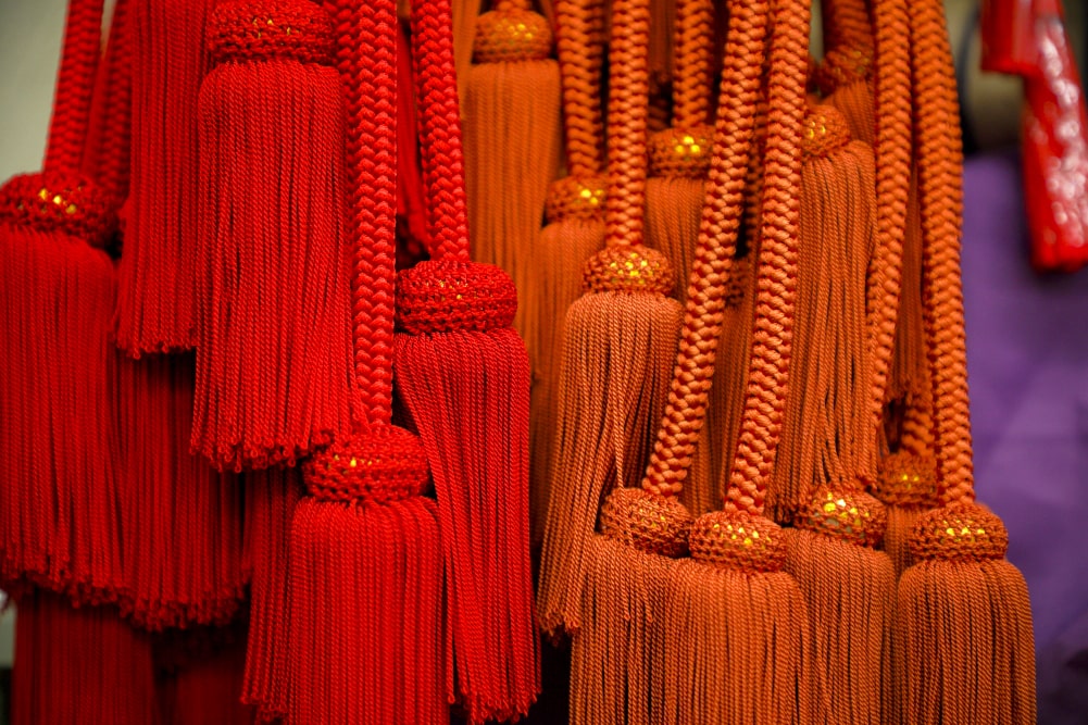 「房師」と呼ばれる専門の職人から届けられた組紐が束ねられていた。こうした色鮮やかな組紐が兜に彩を増す。